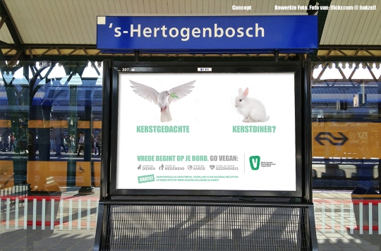 Een banner op station Den Bosch met een duif met de tekst 'Kerstgedachte', een konijn met 'Kerstdiner?' en 'Vrede begint op je bord. Go vegan'