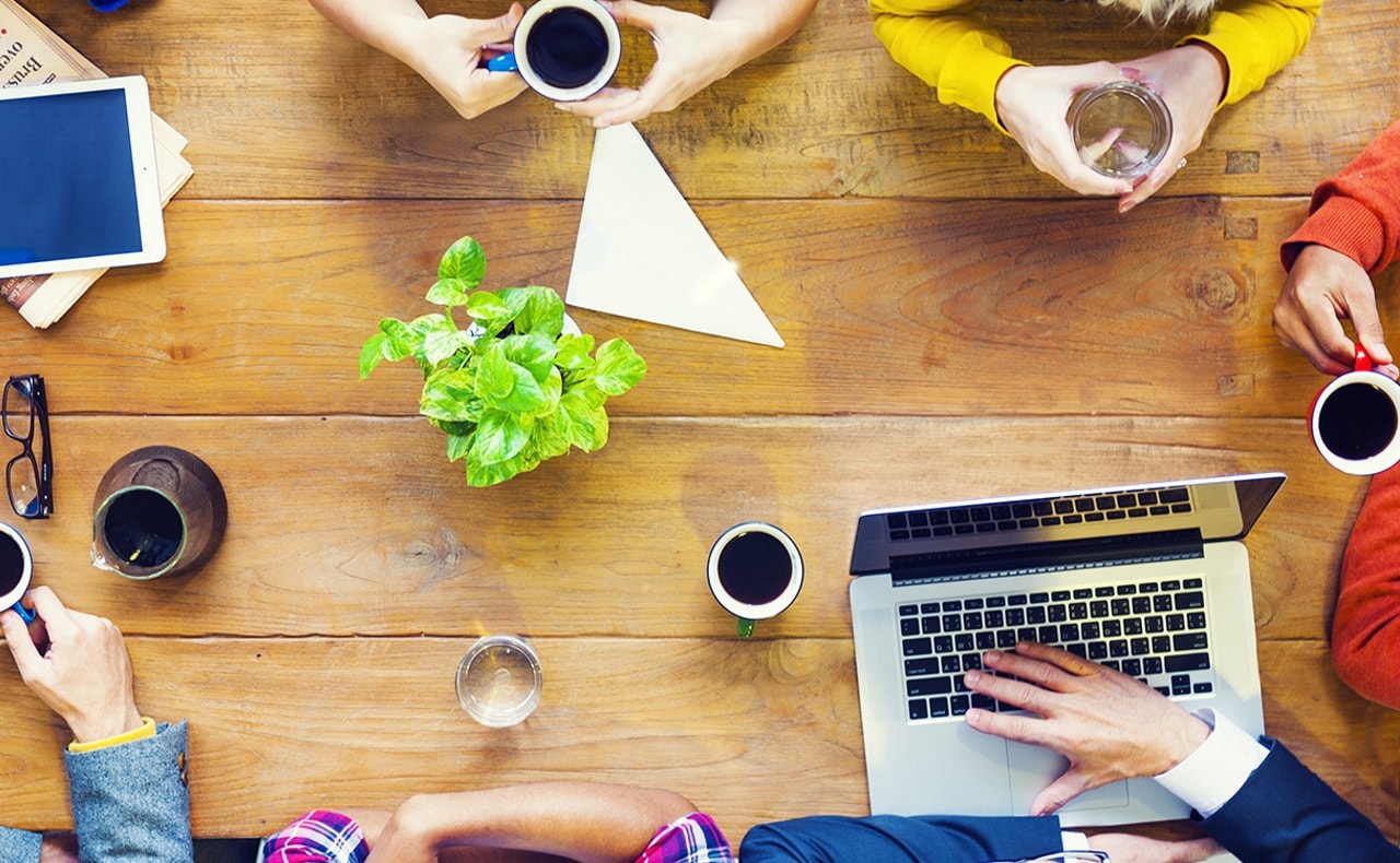 Bovenaanzicht van tafel waaraan mensen een overleg hebben