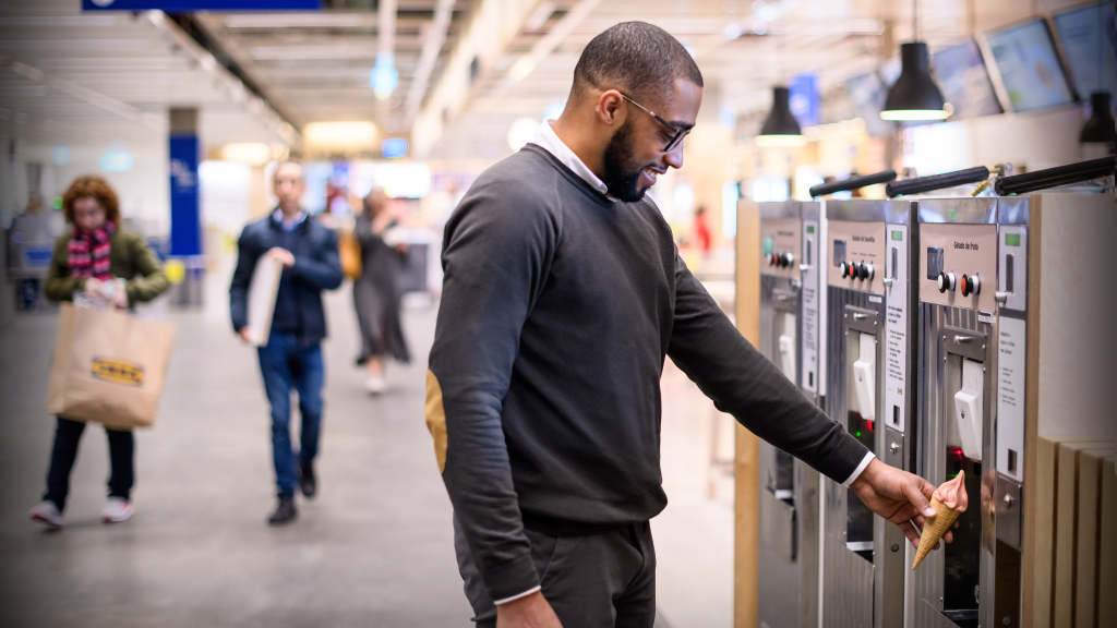 iemand haalt een softijsje uit een ijsmachine