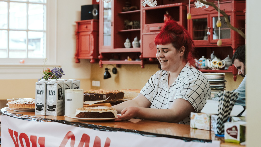 iemand zet een schaal met gebak op een toonbank