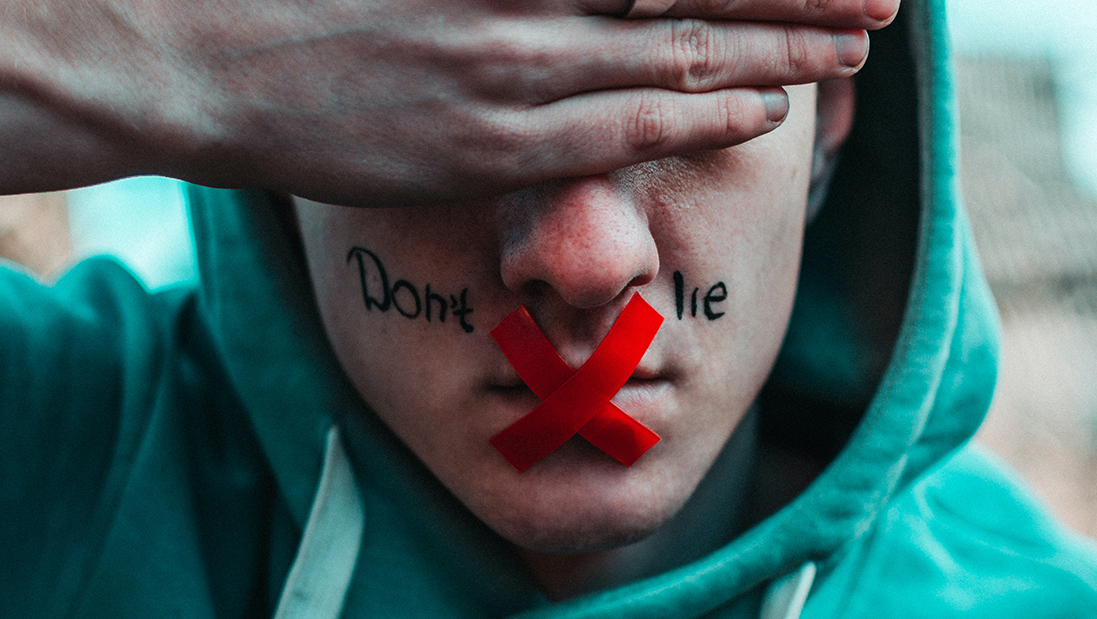iemand met de hand voor de ogen en tape over de mond en de tekst 'Don't lie'
