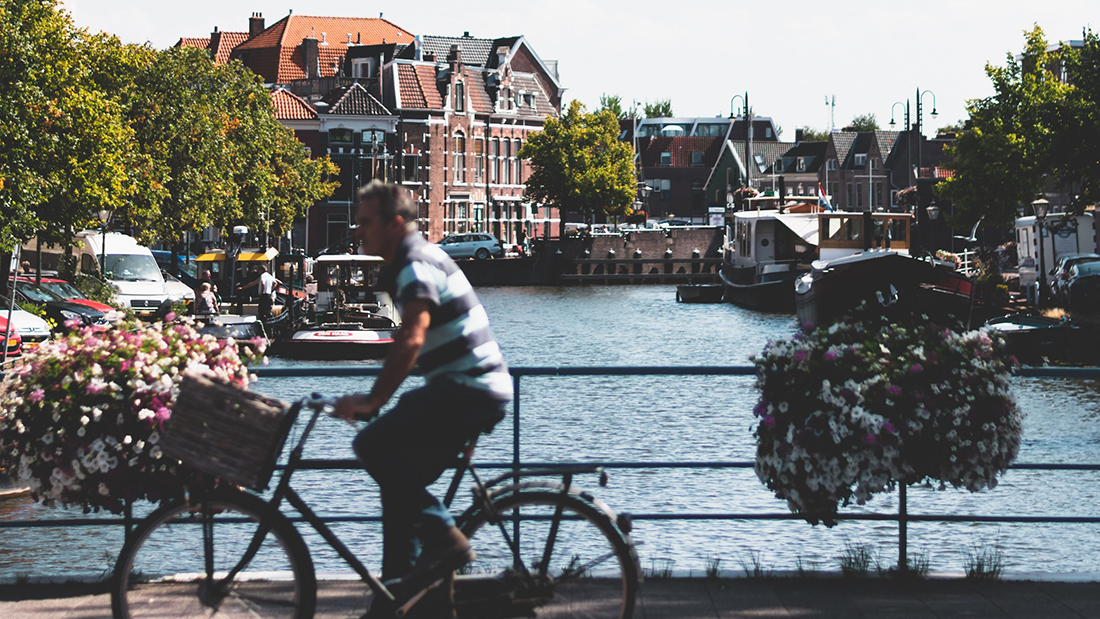 een fietser op een brug over een water in Leiden
