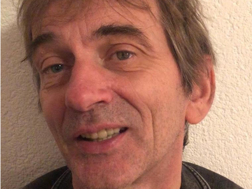 iemand kijkt lachend de camera in