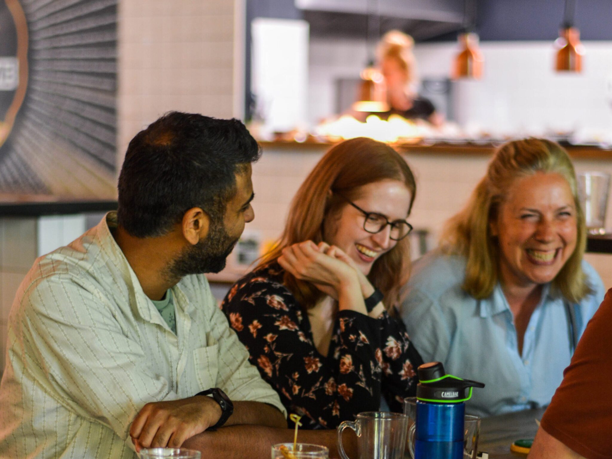 drie mensen zijn lachend met elkaar in gesprek