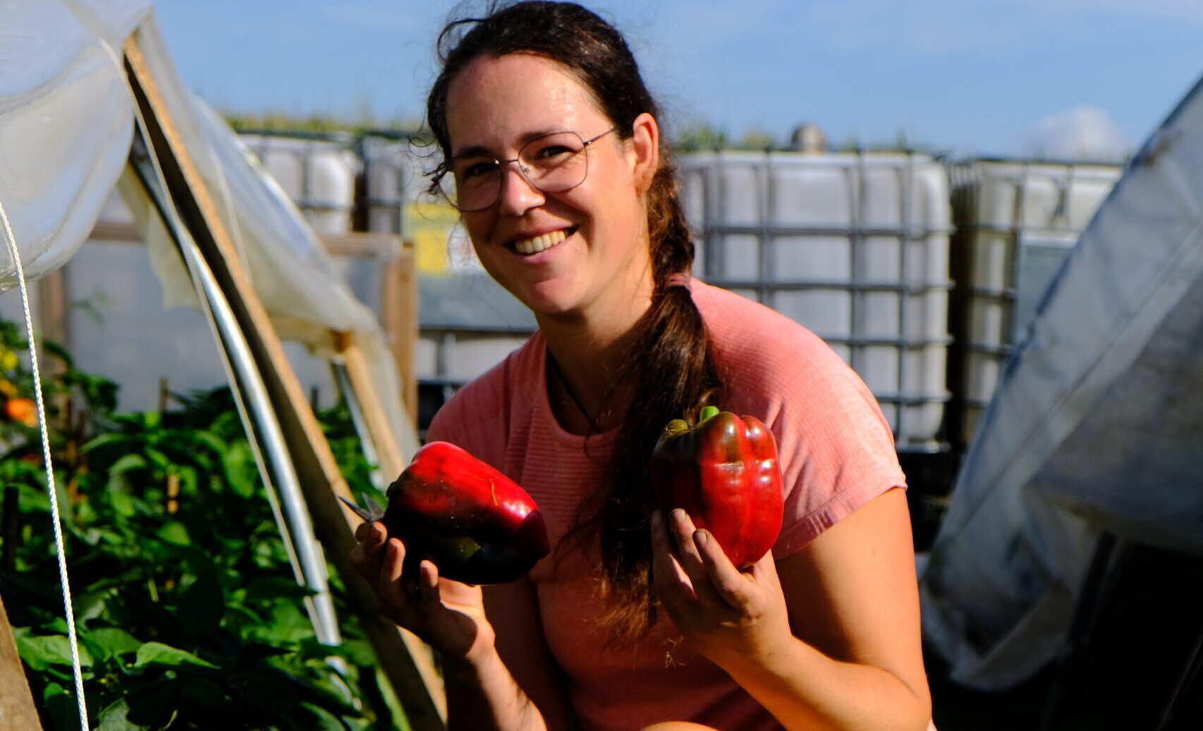 Carolien Caspers houdt lachend in iedere hand een rode paprika.