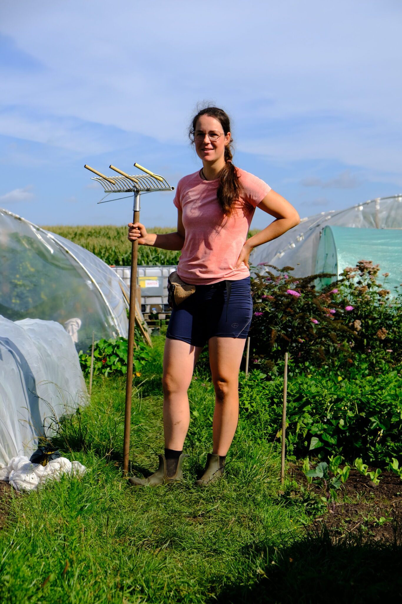 Carolien Caspers met een hark in de hand in haar tuinderij.
