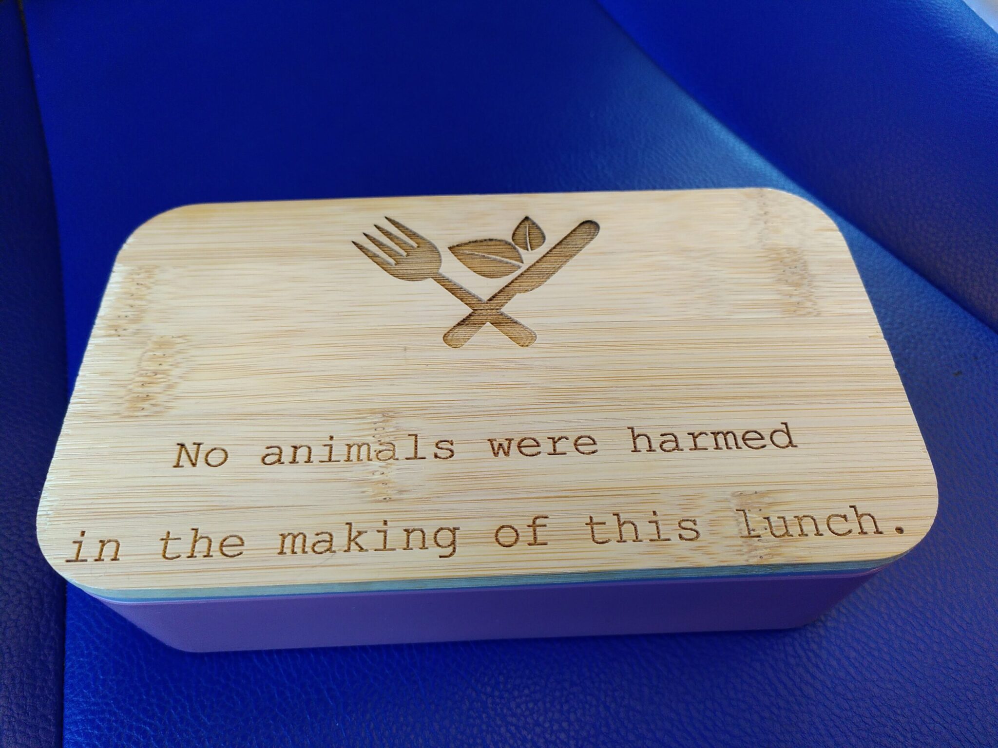 Lunchtrommel met op het houten deksel ingegraveerd de tekst ‘No animals were harmed in the making of this lunch’.
