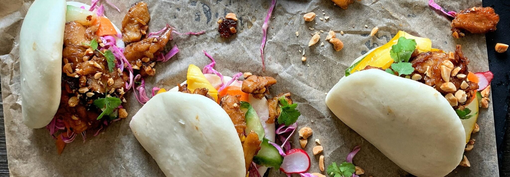 drie broodjes gevuld met een vegan vleesopvolger en groenten