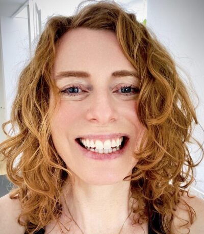 Marijke Hoebee Fotograaf Marijke Hoebee, een vrouw met rood haar en een stralende glimlach.