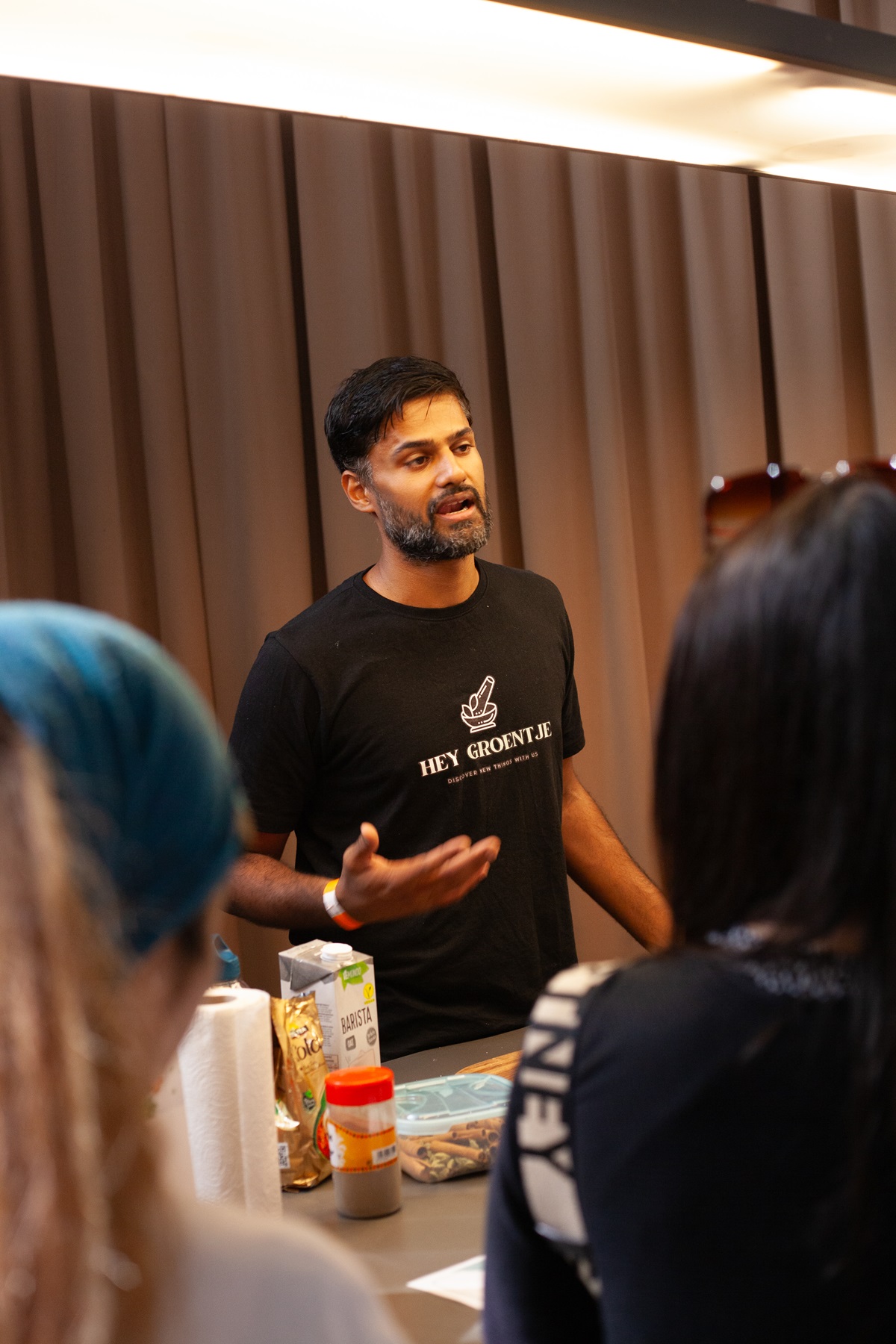 nlvegan-fair_hey-groentje Een medewerker van Hey groentje die bezoekers uitleg geeft tijdens de kookdemo.