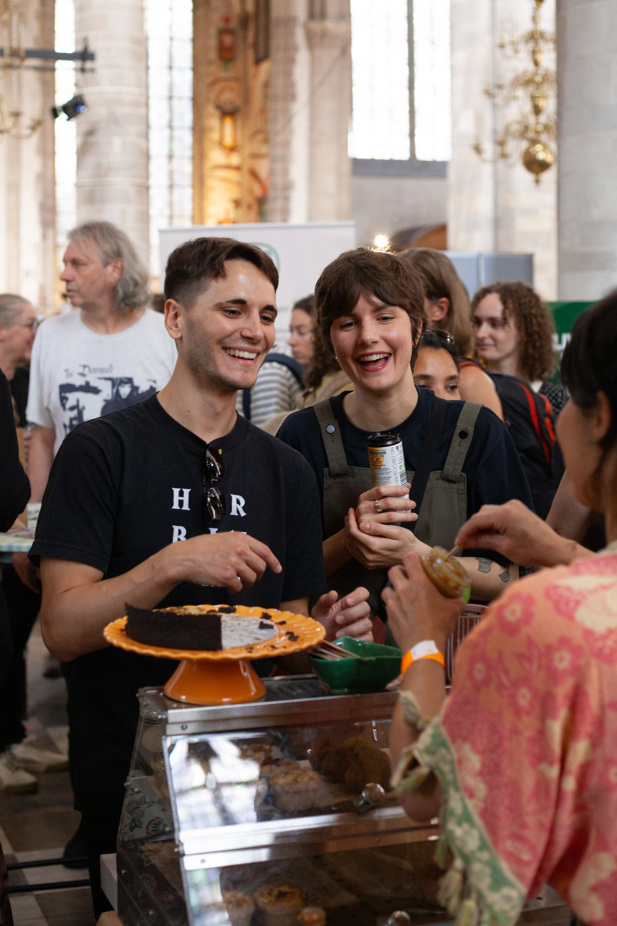 nlvegan-fair_lachende-bezoekers Twee lachende bezoekers die voor 1 van de vele kraampjes staan.