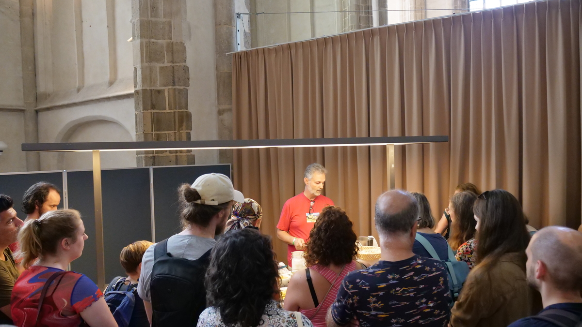 nlvegan-fair-kookdemo-kaasmaken Hans Kuipers die bezoekers uitlegt hoe je kaas kan maken.