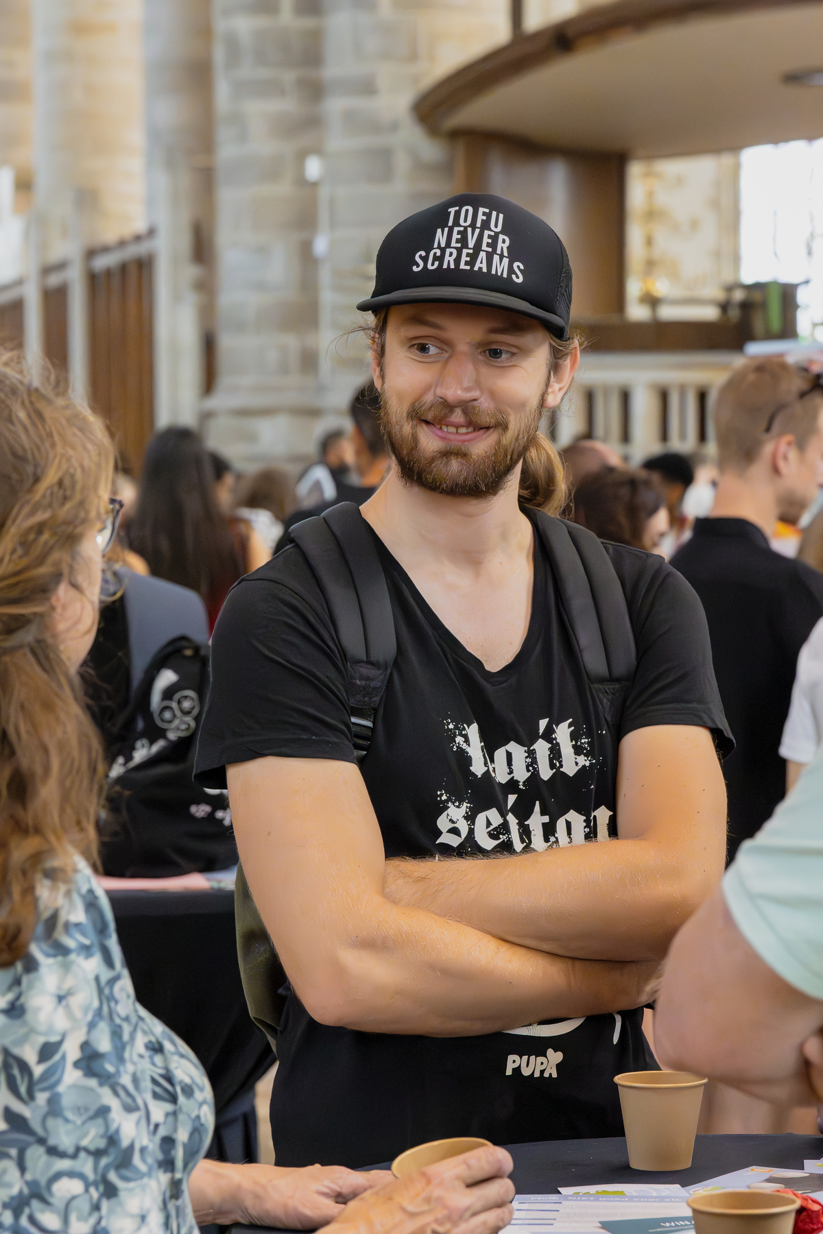 Jongeman op NLVegan Fair met leus op pet Bezoekers met elkaar in gesprek tijdens de NLVegan Fair 2024.