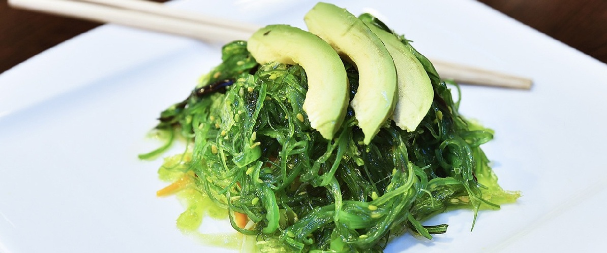 Zeewier met schijfjes avocado op een bord