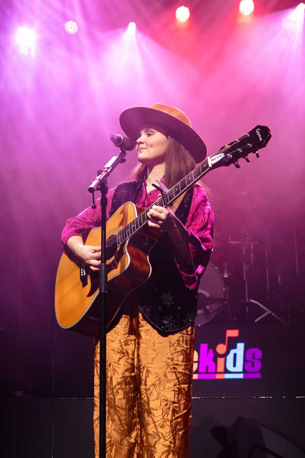 Fleur Smits met gitaar en microfoon