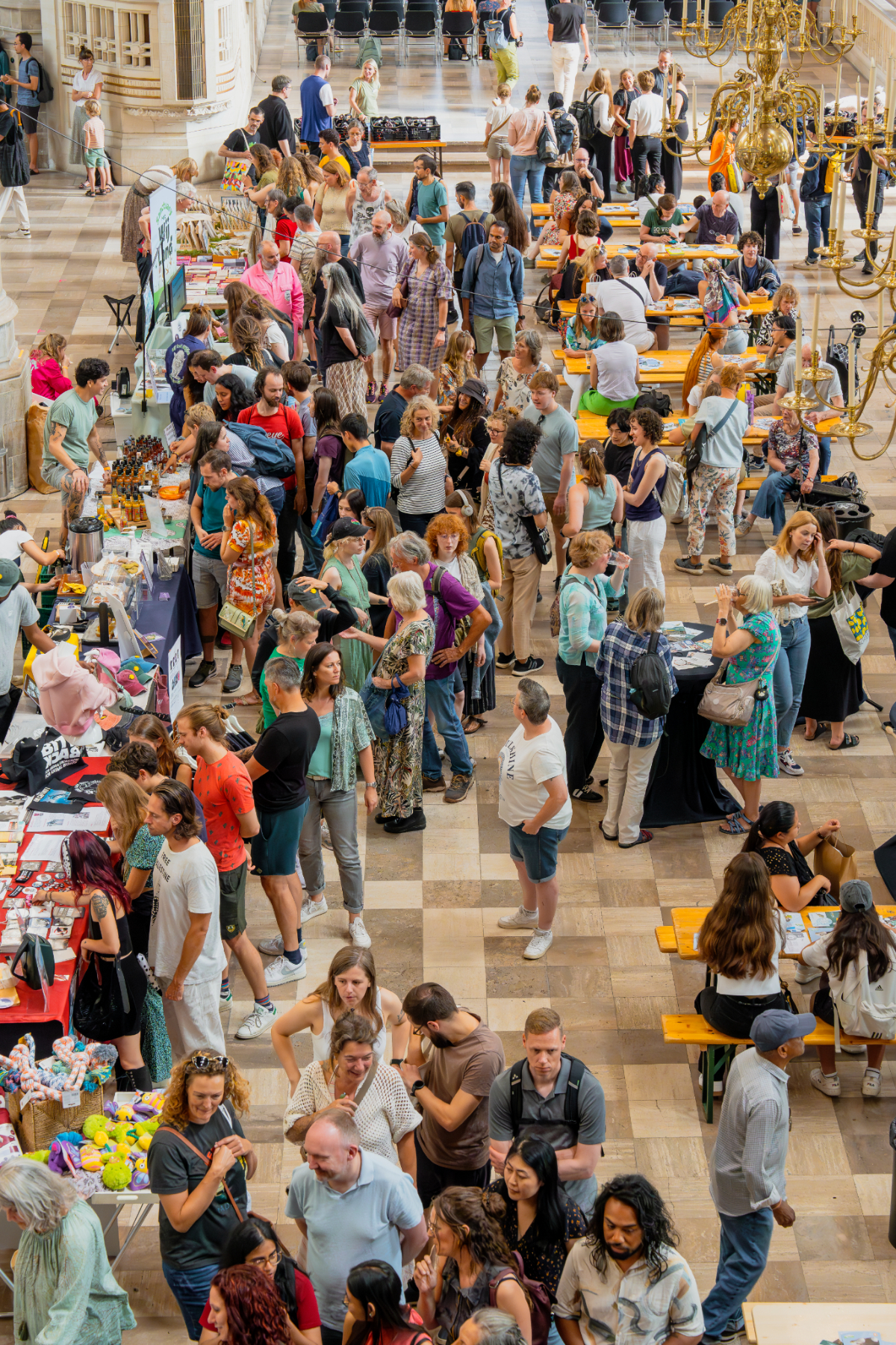 NLVeganFair-standoverzicht2024 Bovenaanzicht van mensen die tussen de standjes op de NLVegan Fair door lopen.